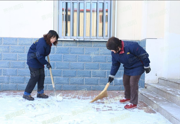 揮舞著鐵鍬和笤帚，相互配合掃雪圖片